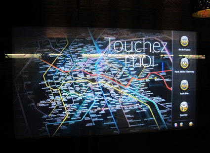 An interactive map at Franklin Roosvelt Paris metro station and an advertising buildboard at the same location. Photos by Carola Moujan.