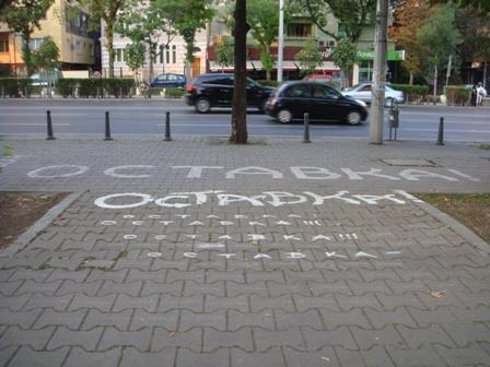 Graffiti text: “Resignation” (In Bulgarian) painted in huge size on the pavement of “Tzarigradsko chausee” at the section after the iconic “Eagle’s Bridge”  in Sofia, leading towards the square where the National Assembly (Parliament) is located. The “Eagle’s Bridge” intersection became symbolic for protest marches and traffic closure all along 2013 by the mass civic protests. Image Source: Kiril Avramov
