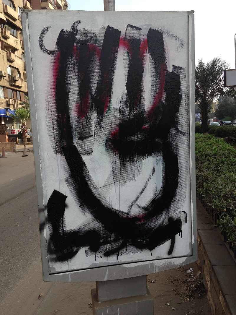 “Rabaa-hånden”, en hånd med fire utstrakte fingre, symboliserer mordet på hundrevis av pro-Morsi-protestanter på Rabaa-plassen i august 2013. Den opprinnelige tegningen er delvis synlig som rødmaling under den sorte "utviskingen". El Maadi, Cairo 2014